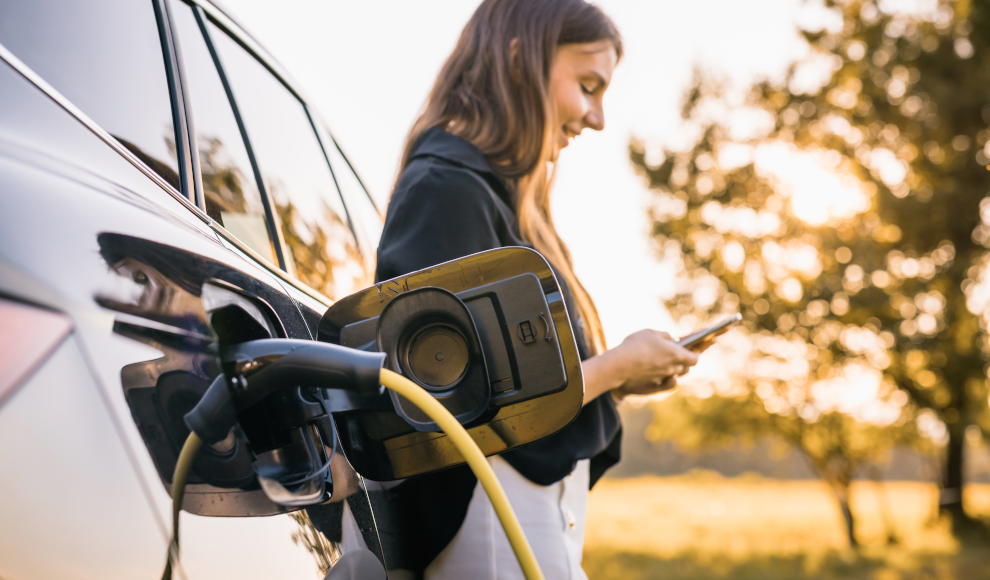 Frau lädt Elektroauto