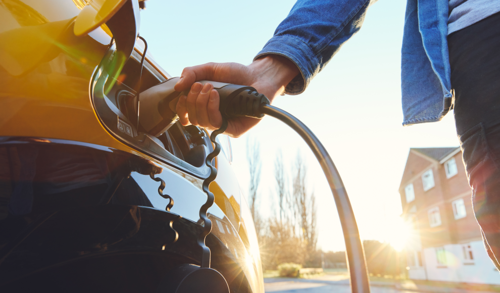 Mann mit Herzschrittmacher lädt ein Elektroauto