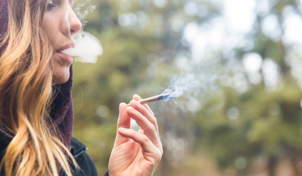 Frau konsumiert eine Cannabiszigarette