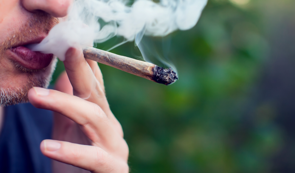 Mann konsumiert eine Cannabiszigarette