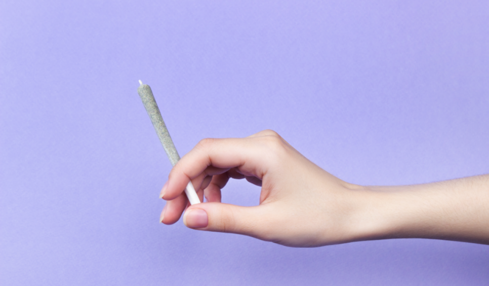 Frau konsumiert eine Cannabiszigarette (Joint)