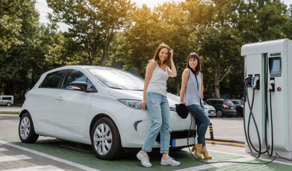 Junge Frauen mit einem Elektroauto