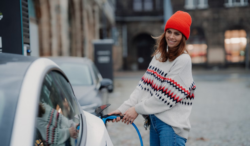 Frau lädt Elektroauto