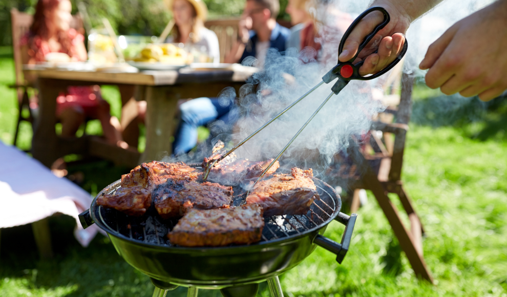 Mann grillt Fleisch trotz des Klimawandels