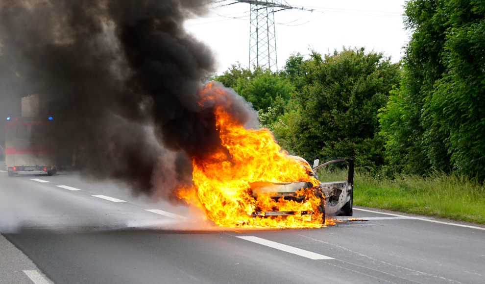 Brennendes Auto auf einer Landstraße