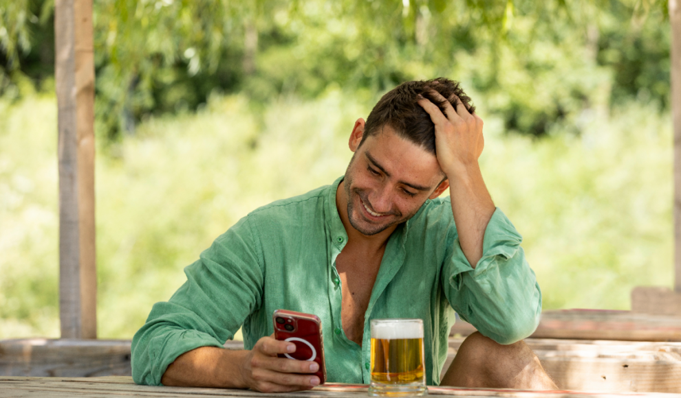 Mann prüft seinen Alkoholpegel mit seinem Smartphone